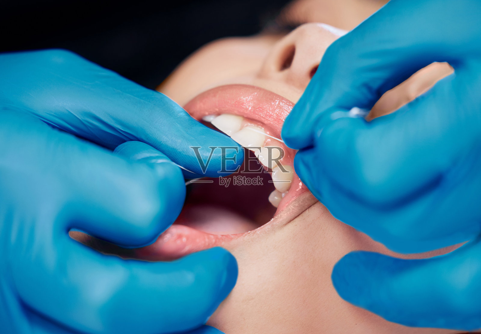 一个女人在牙医办公室用牙线剔牙的照片照片摄影图片