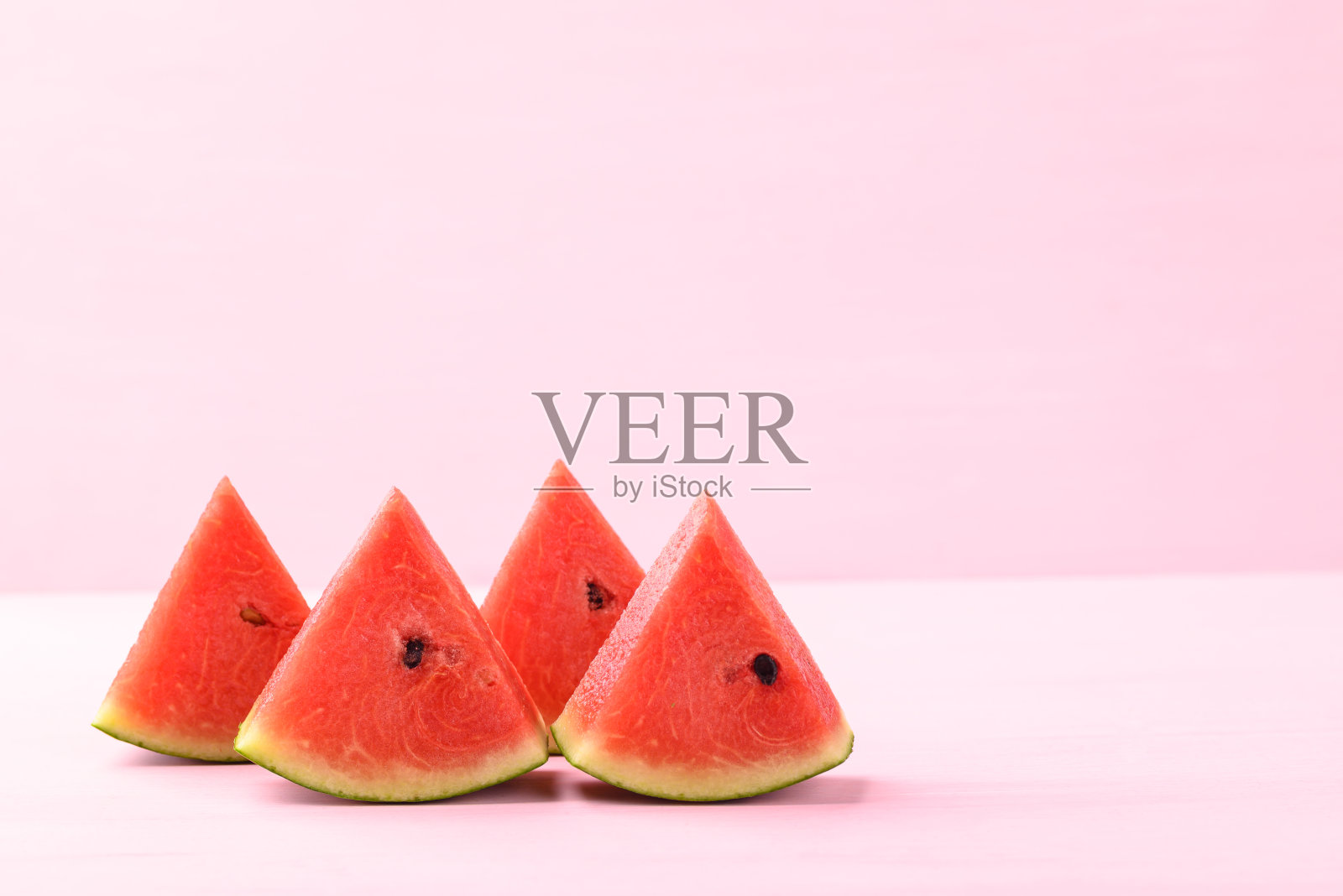 切成薄片的西瓜在粉红色的背景照片摄影图片