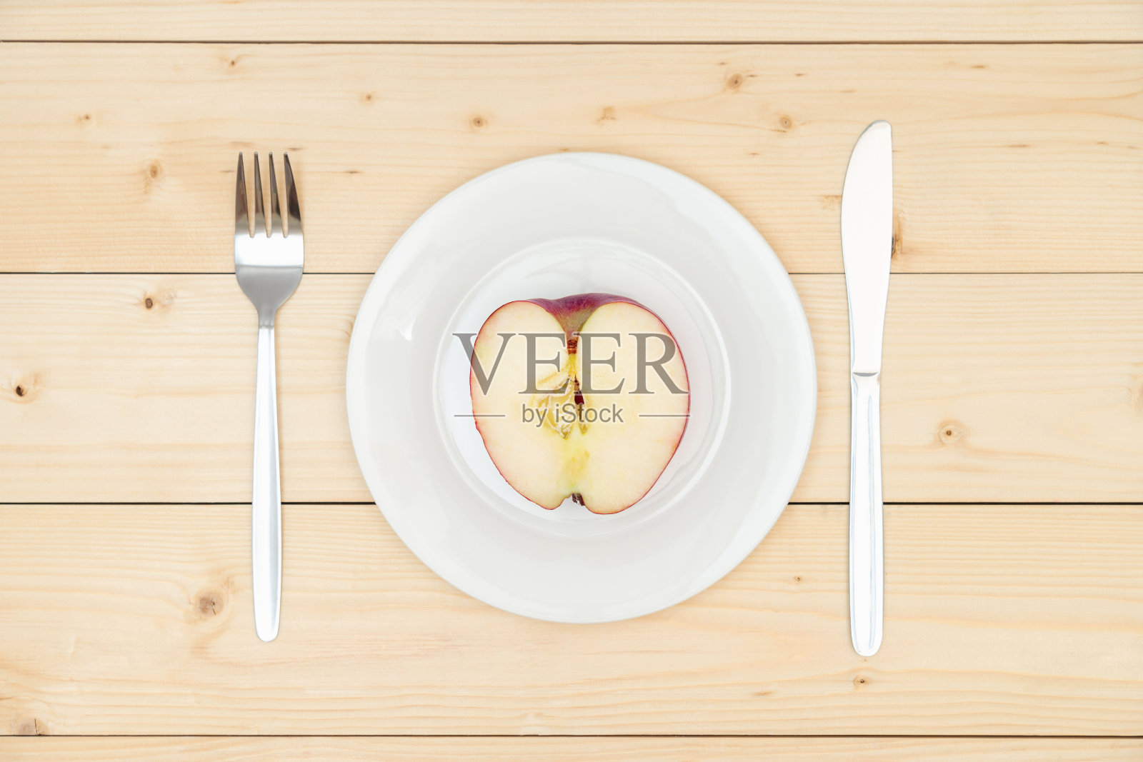 半个红苹果在一个白色的盘子上,俯视图照片摄影图片