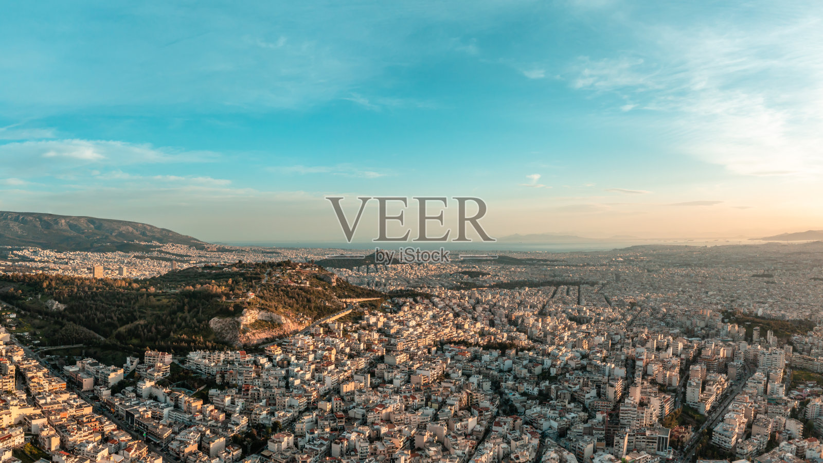 从北方拍摄的雅典日落、黄昏的航拍全景照片——Psychiko、Chalandri、Marousi、Galatsi、附近的山丘和Psychiko废弃的采石场,一直到海边照片摄影图片