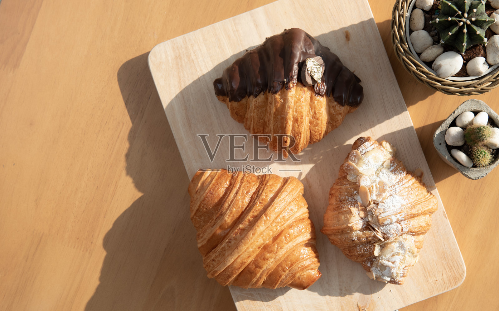 自制的半块巧克力牛角面包,坚果片面包屑放在桌上照片摄影图片