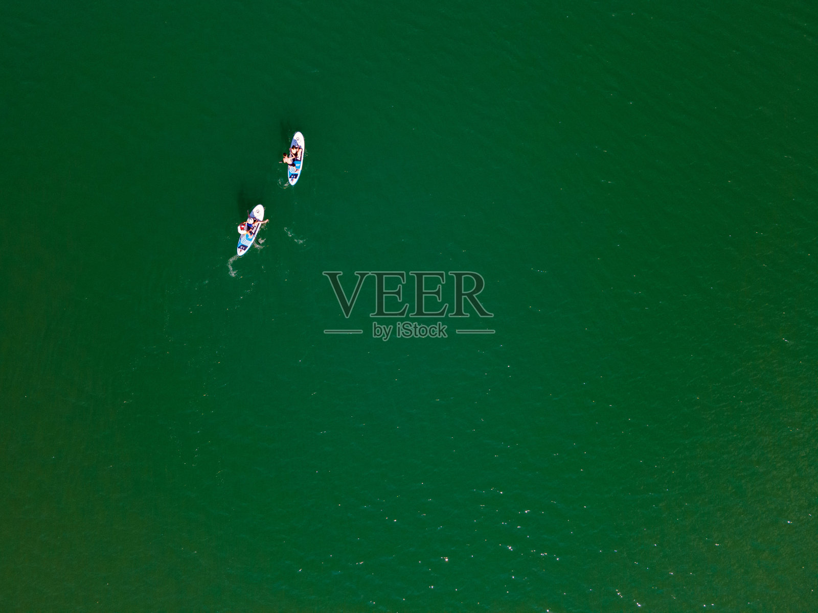 俯视图,人们在湖中央的桨板上照片摄影图片