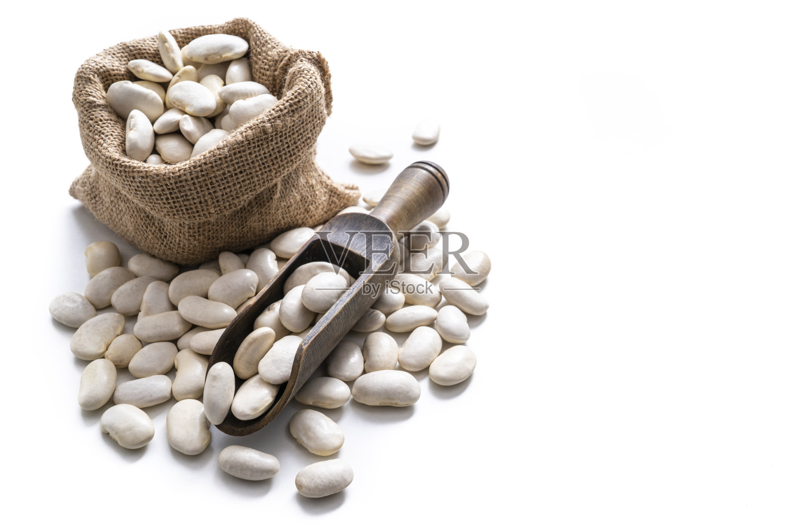 白色蚕豆干豆类在粗麻袋袋和木制服务勺孤立在白色照片摄影图片