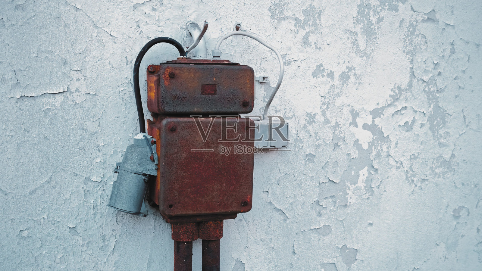户外电保险丝盒,带电源插座,金属外壳生锈,安装在旧建筑墙上照片摄影图片