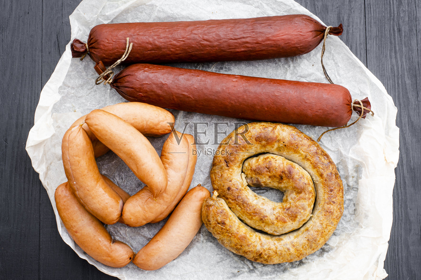 木制背景上不同类型的天然香肠。照片摄影图片