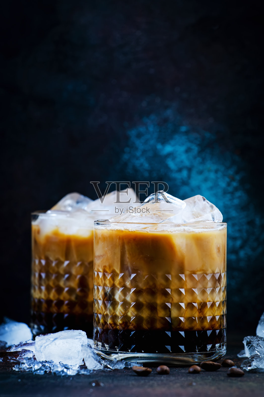 时尚的酒精鸡尾酒与伏特加,咖啡利口酒,奶油和冰在黑暗的背景,铜酒吧工具。负空间照片摄影图片