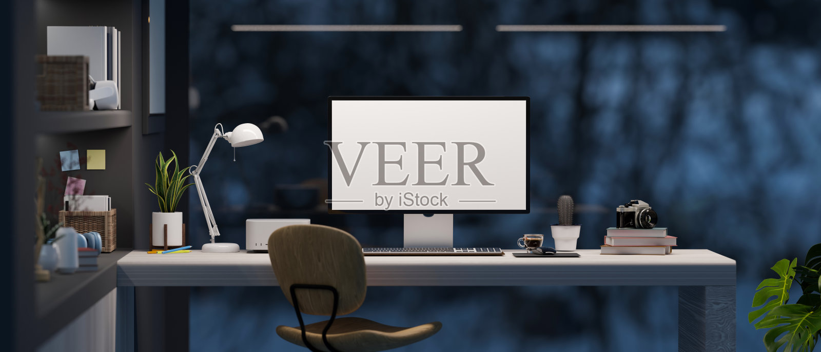 宽敞的现代办公空间与pc桌面计算在黑暗的房间在晚上。照片摄影图片