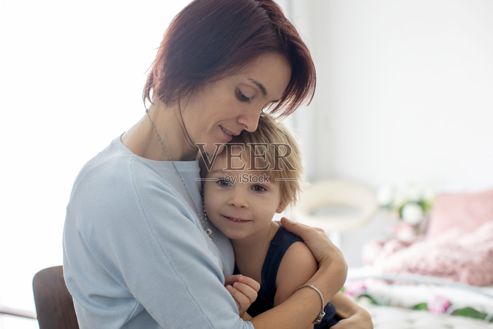 母亲和孩子的肖像,拥抱在背光白色背景照片摄影图片