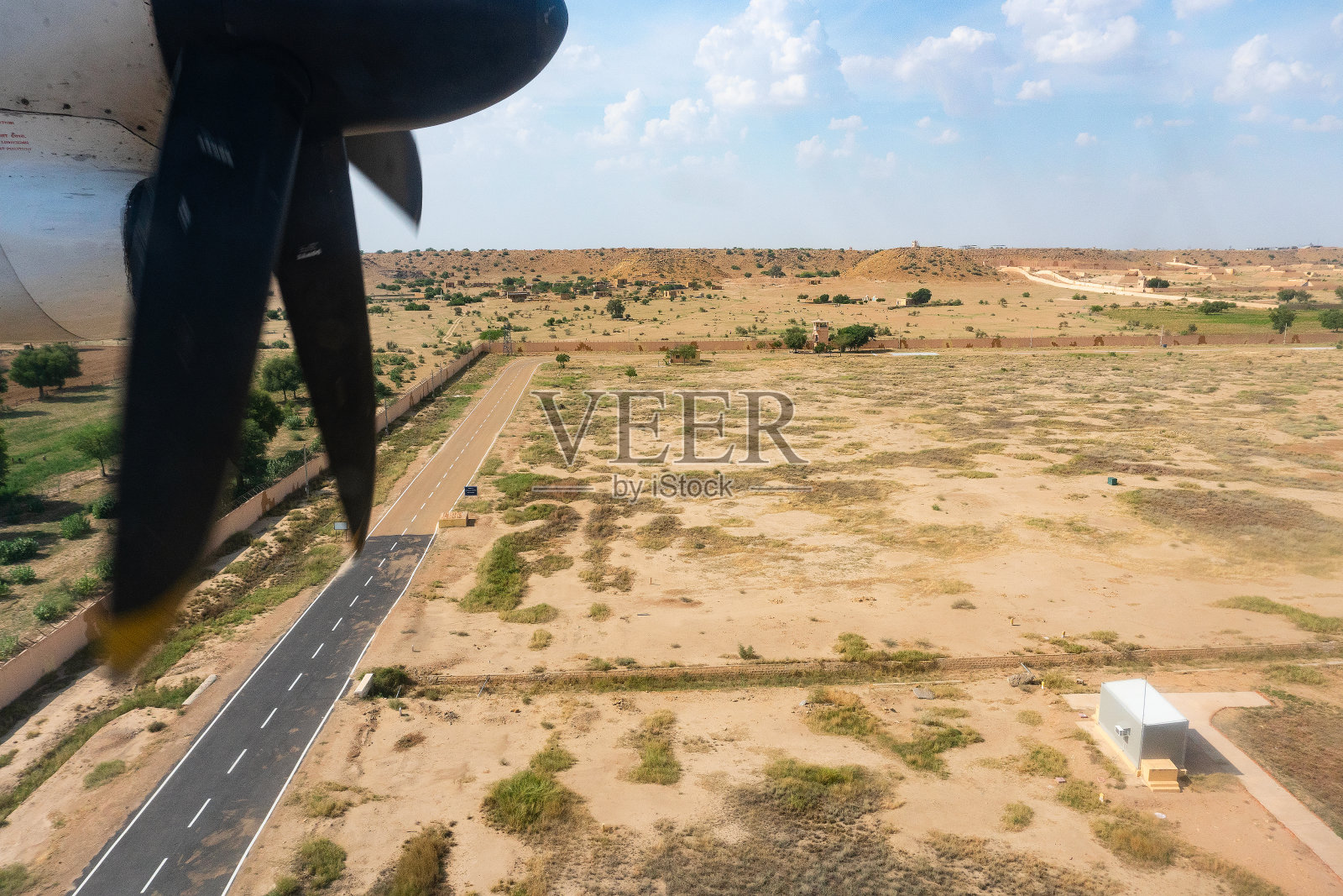 从飞机上看到的塔尔沙漠,印度拉贾斯坦邦。螺旋桨、贾伊沙尔默机场的着陆跑道和画面中的沙漠。照片摄影图片