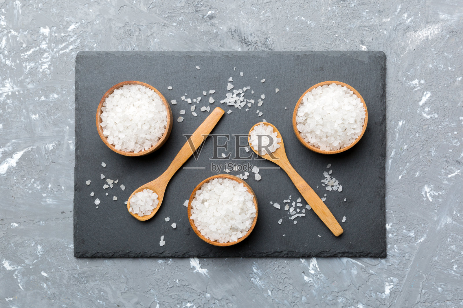 木碗上的盐晶体在木制的背景上。盐在乡村碗,顶视图与复制空间照片摄影图片