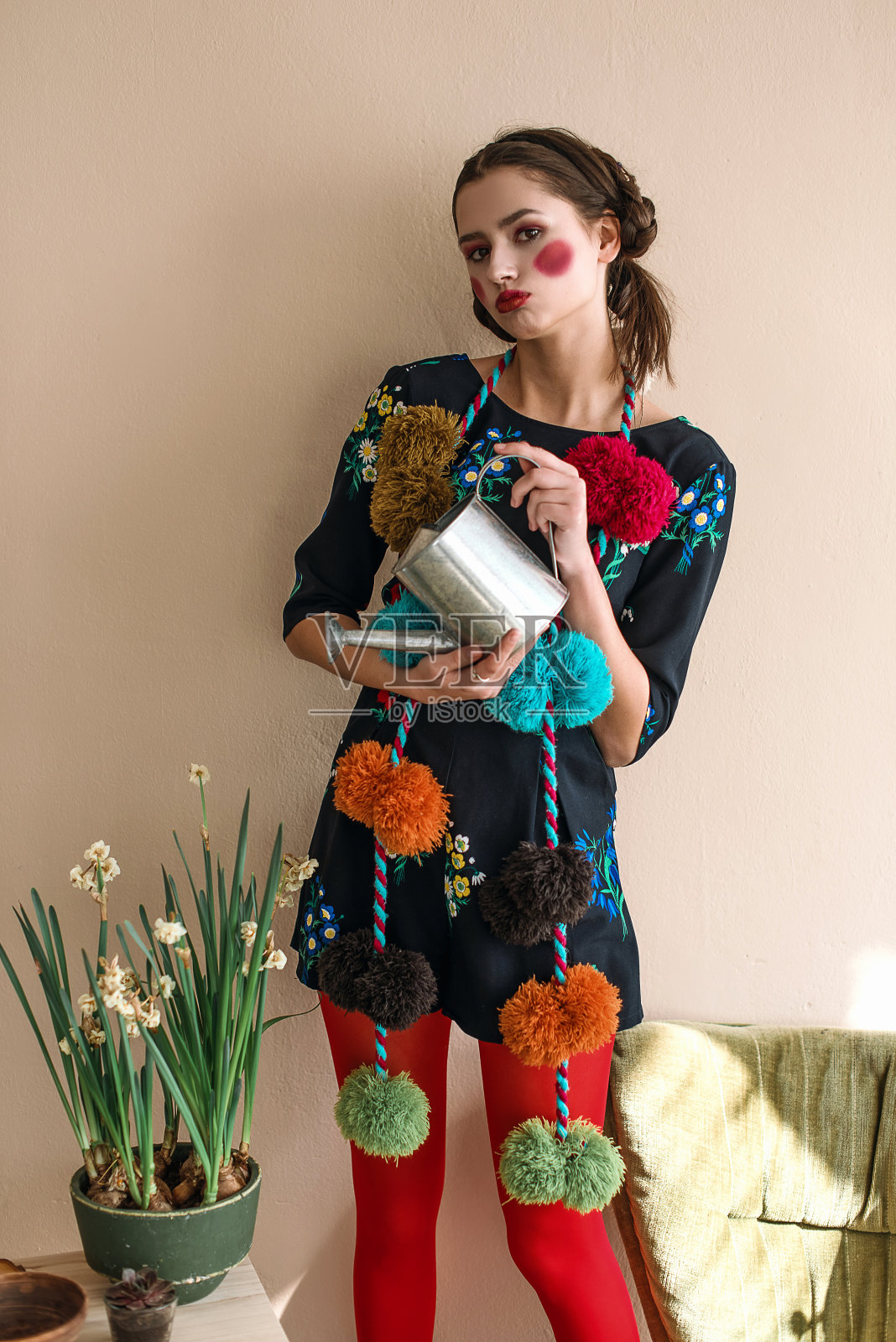 时尚美丽的黑发女孩在连体衣花卉刺绣与彩色化妆:红色的脸颊和嘴唇有乐趣,浇花。奶奶别致的风格。过肖像照片摄影图片