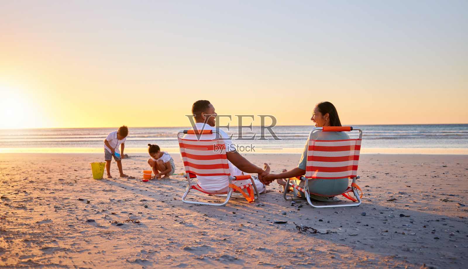 这张照片拍摄的是一个美丽的家庭在海滩上度过的一天照片摄影图片
