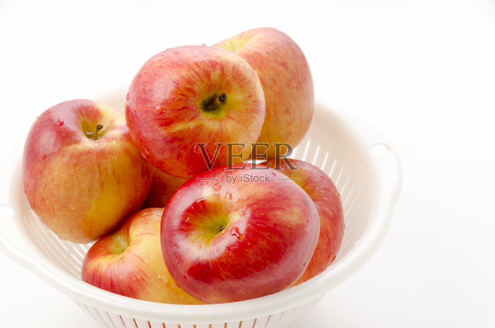 爵士苹果在白色的塑料滤锅在白色的背景照片摄影图片