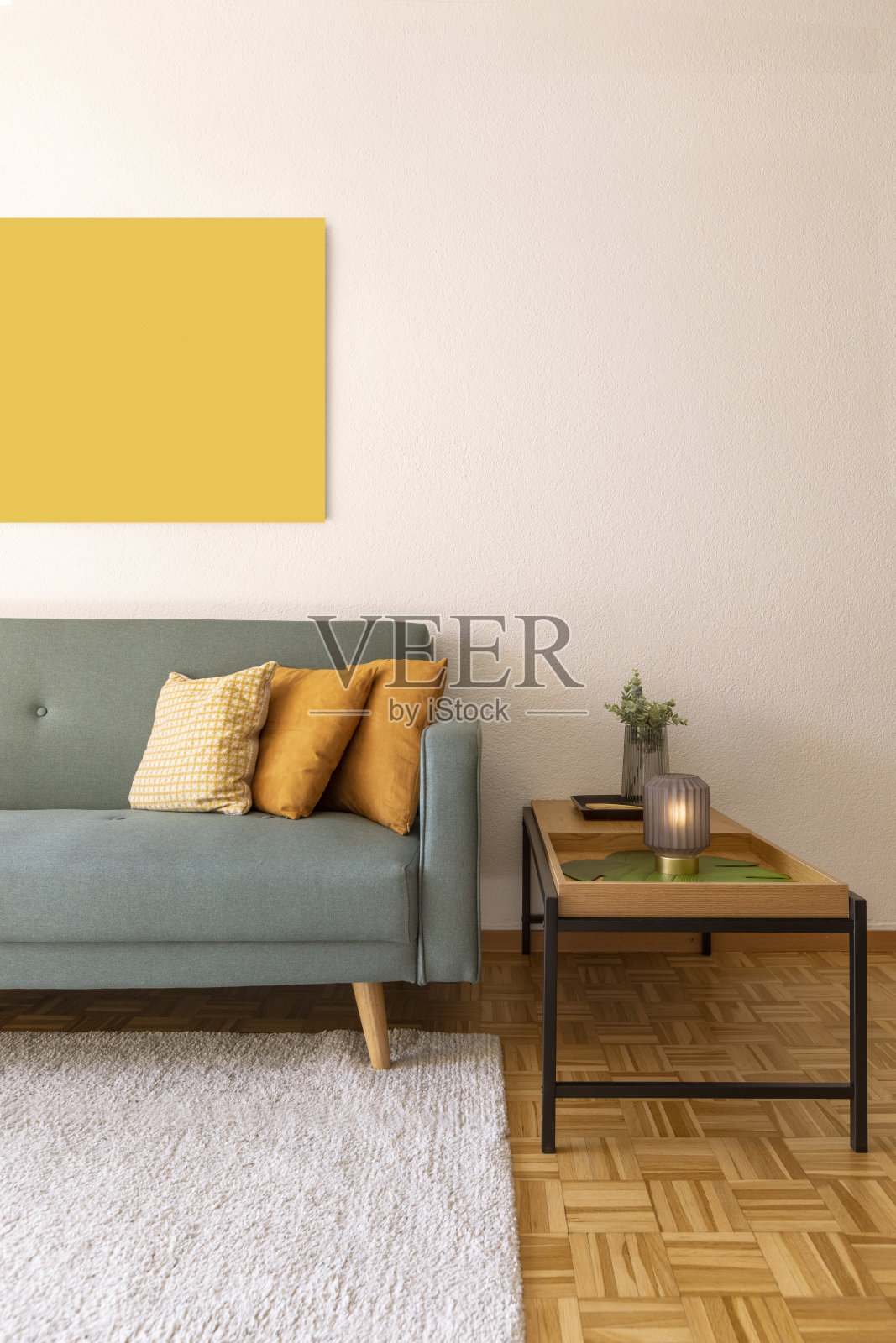 灰色沙发细节与黄色靠垫和现代咖啡桌。墙上有一幅画照片摄影图片
