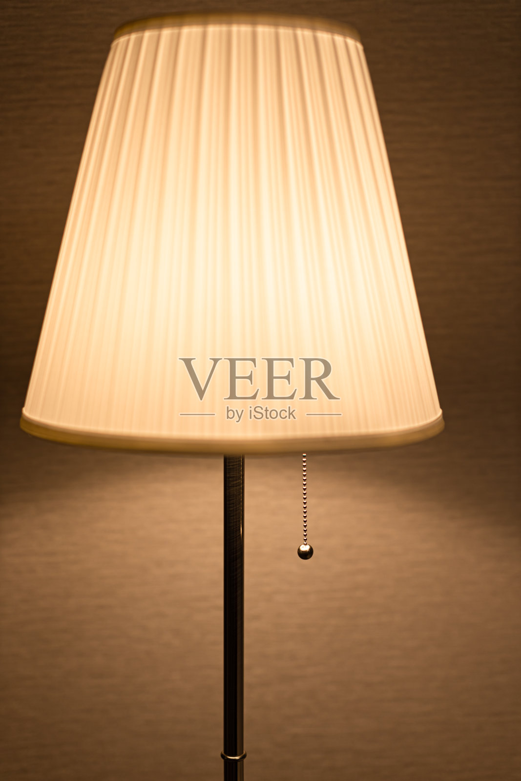 一盏带灯罩的落地灯以墙为背景照片摄影图片