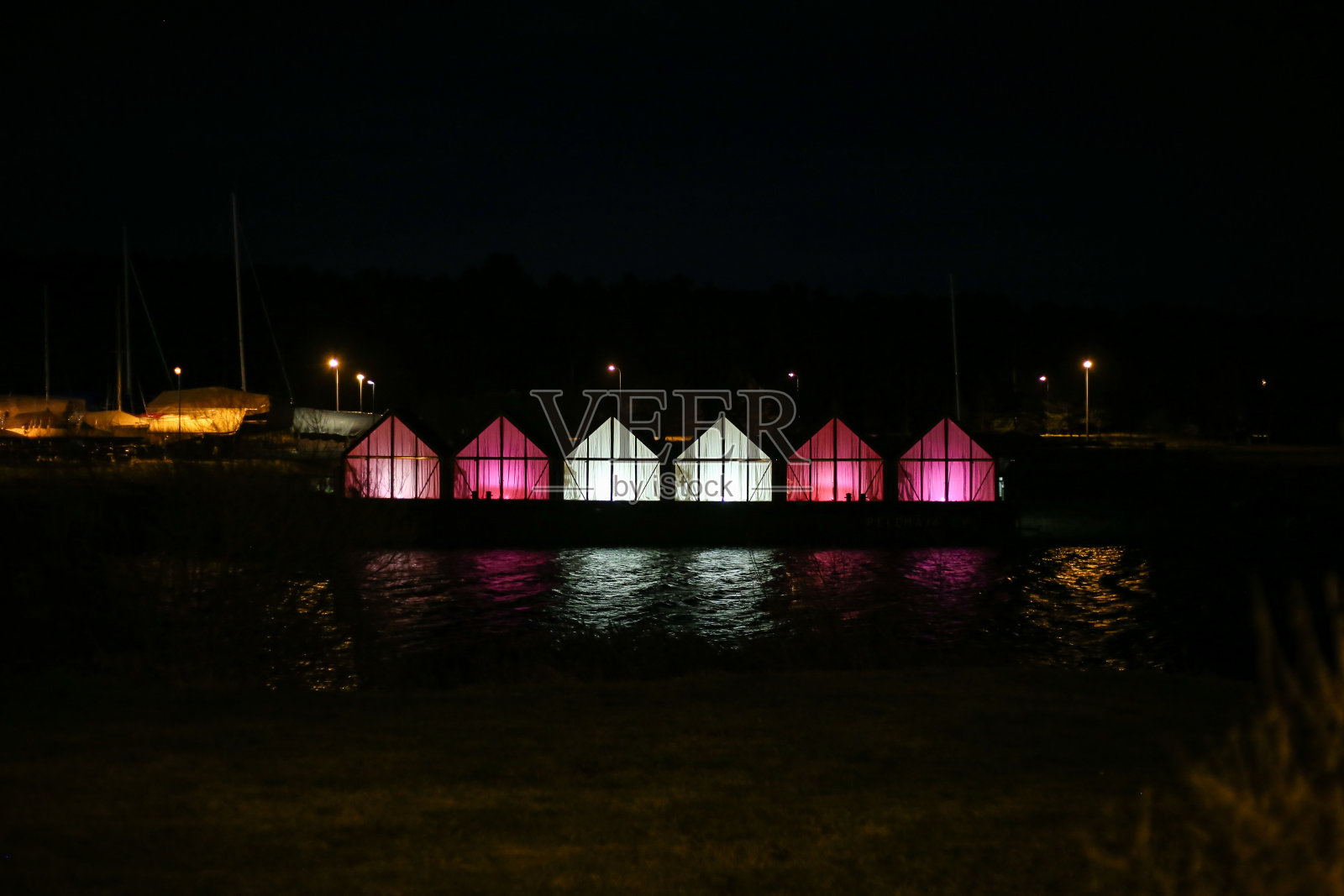 可爱的船屋在小河边与拉脱维亚国旗的颜色。照片摄影图片