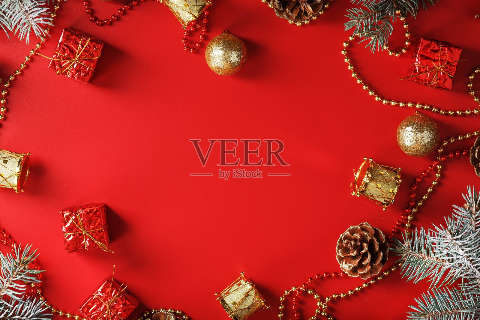 圣诞节布置的圣诞装饰品和圣诞树装饰在红色的背景上。照片摄影图片