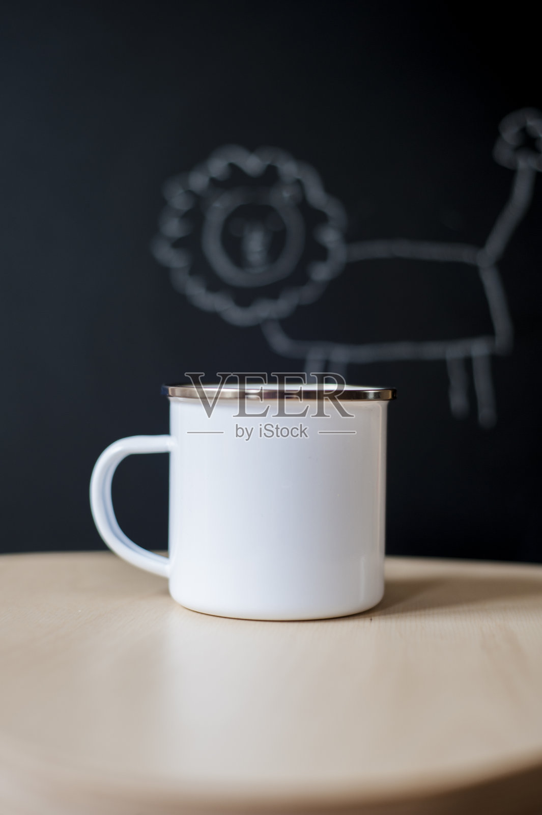 白色搪瓷杯子模型与一个小狮子涂鸦在黑板上作为背景。空白咖啡杯模型的设计推广。- - -库存图片照片摄影图片