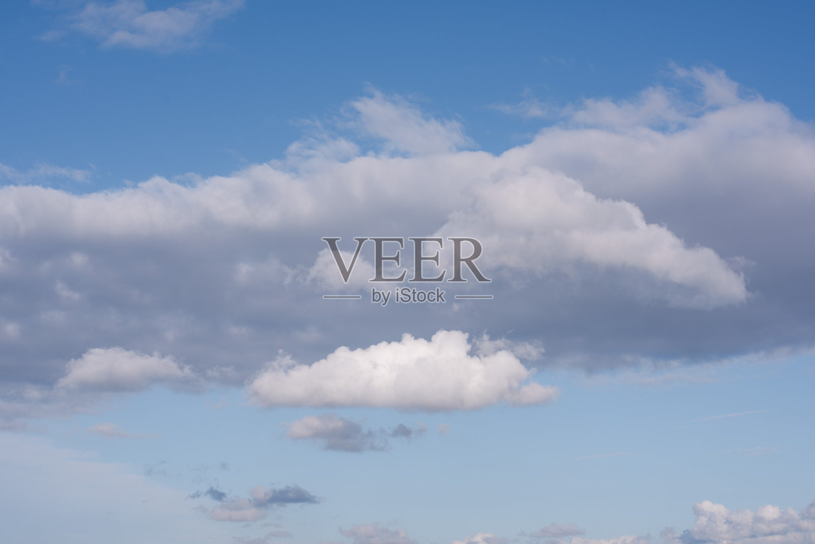 蓬松的云朵在蓝天中更换。照片摄影图片