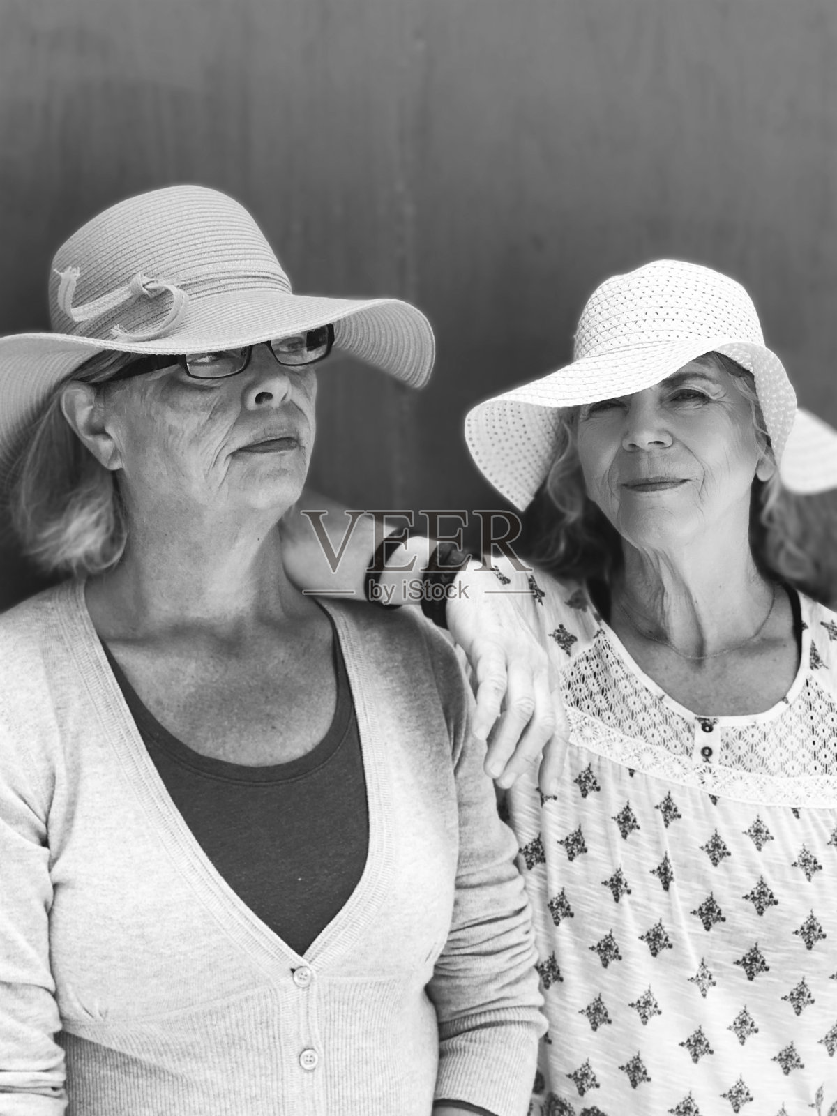 两个戴着大草帽的大四姐妹在户外亲密无间的肖像。照片摄影图片