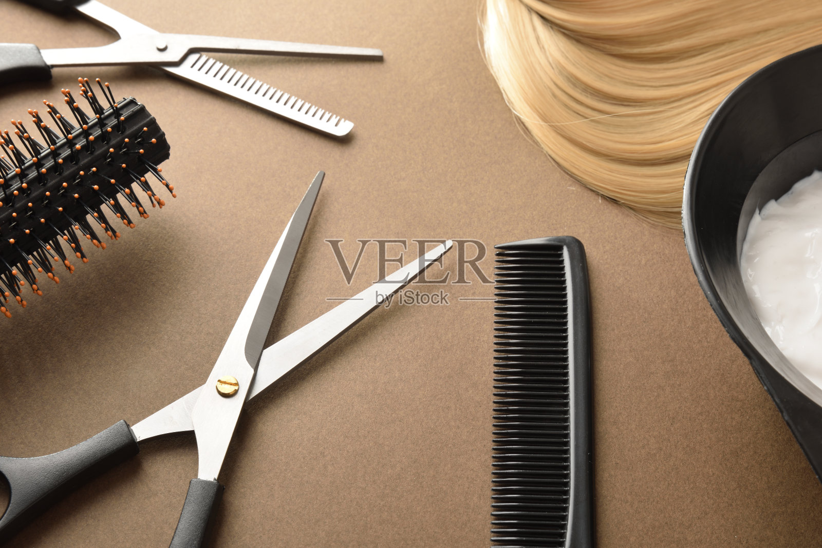 用于在棕色背景上切割和染色头发的理发工具照片摄影图片