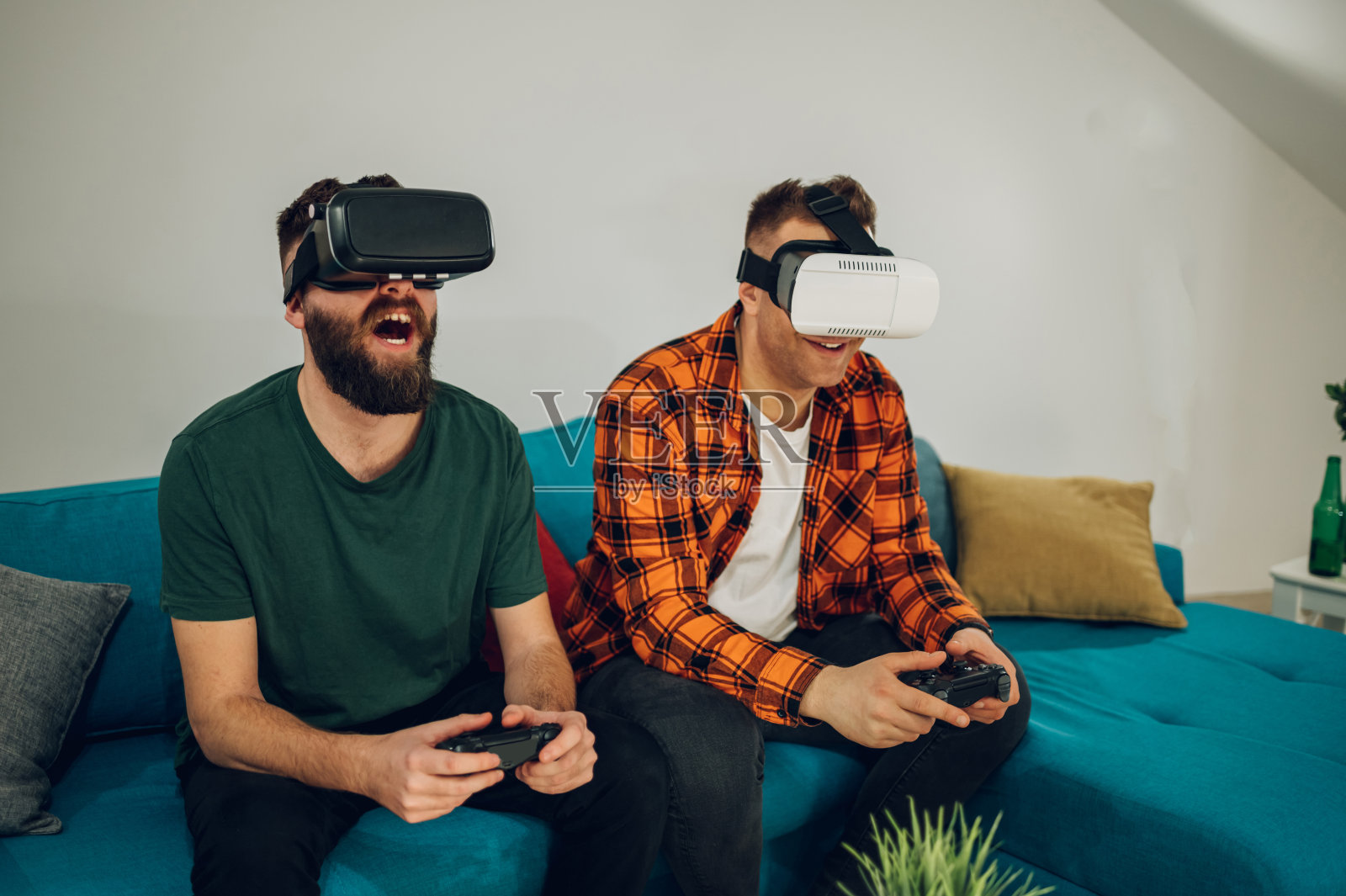 男性朋友在家里戴着虚拟现实眼镜玩电子游戏照片摄影图片