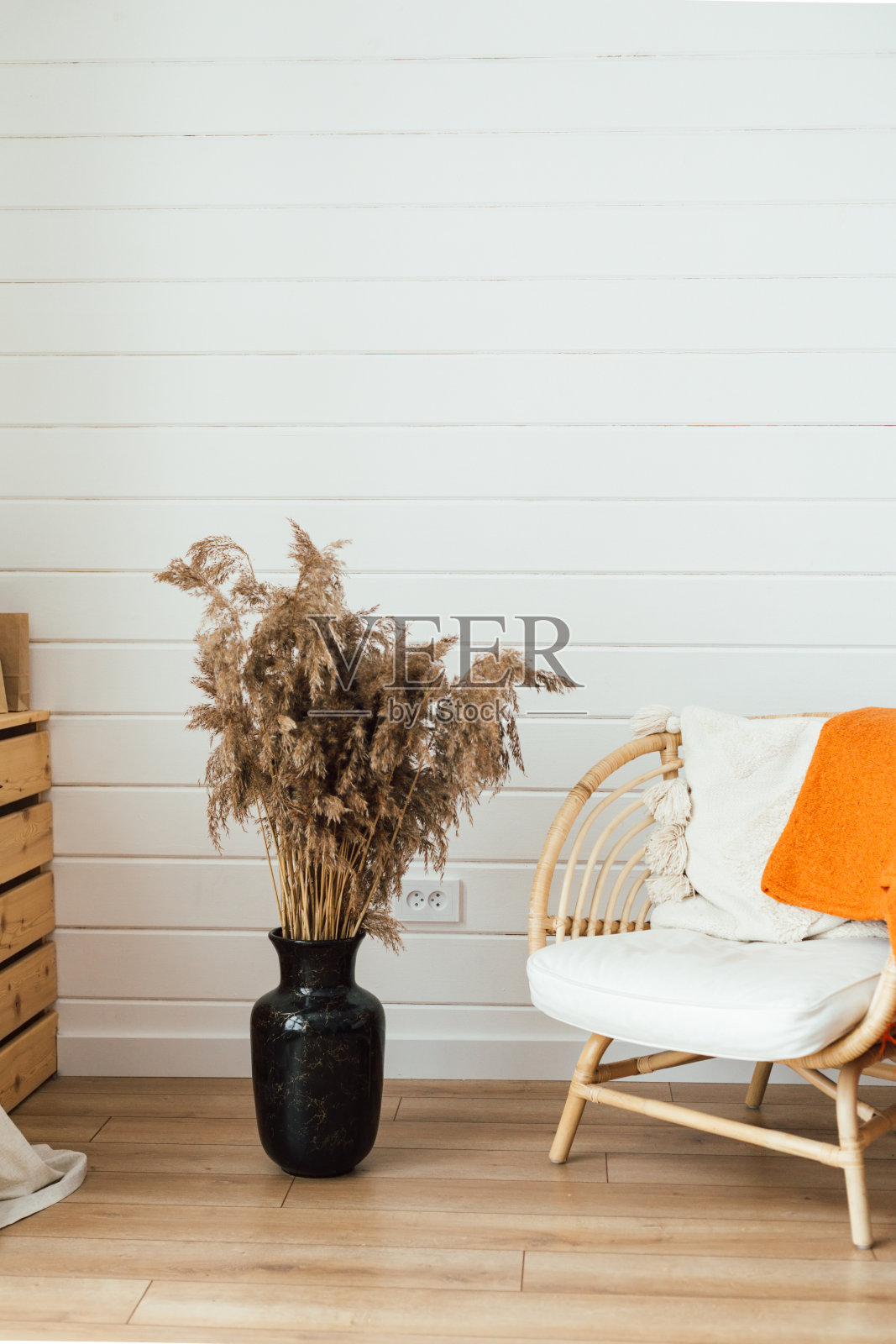 藤椅,落地灯和大花瓶与潘帕斯草在客厅内部。舒适的内饰,波西米亚风格。真实的照片照片摄影图片