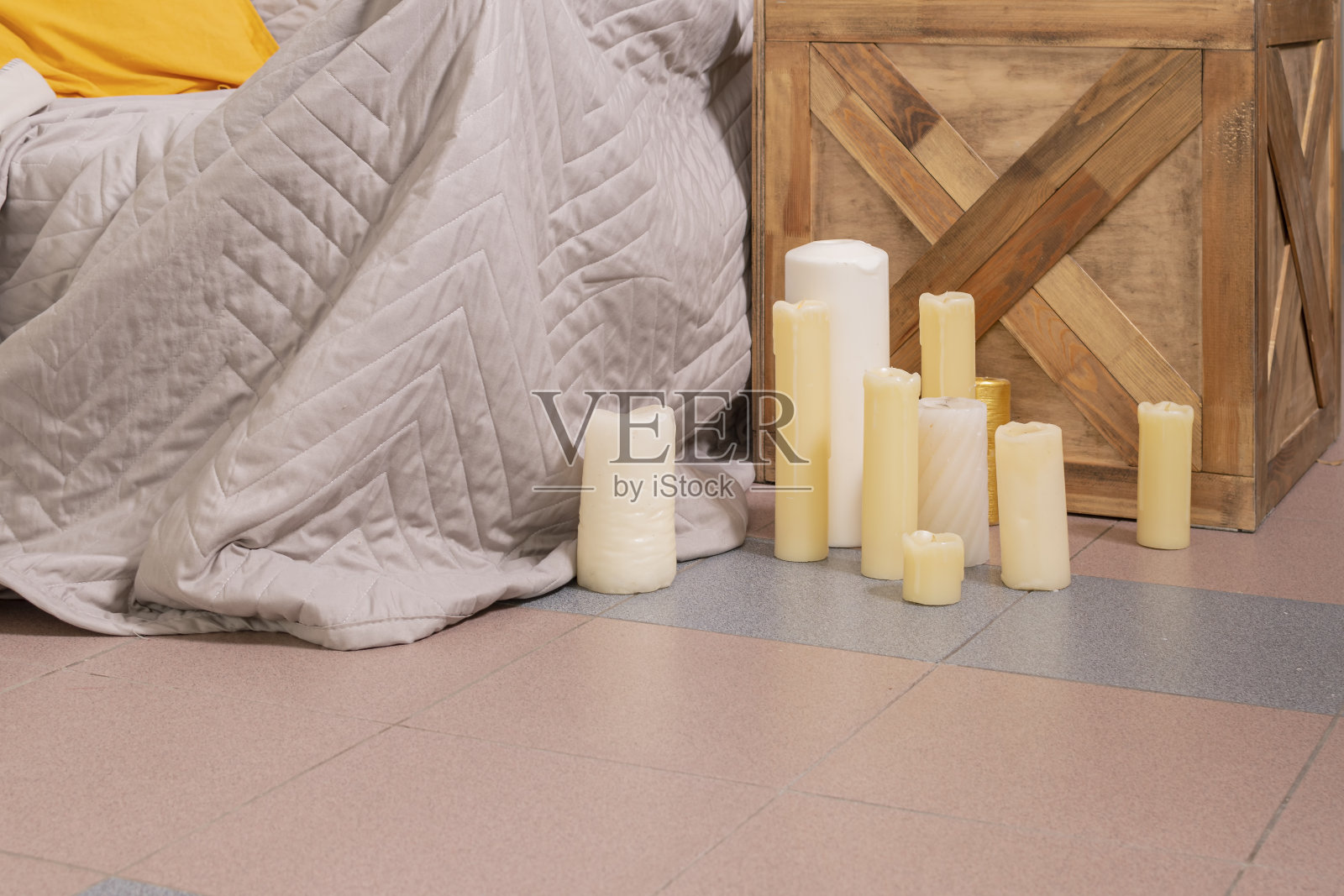 卧室的地板上摆放着一组五颜六色、形状各异的蜡烛。照片摄影图片
