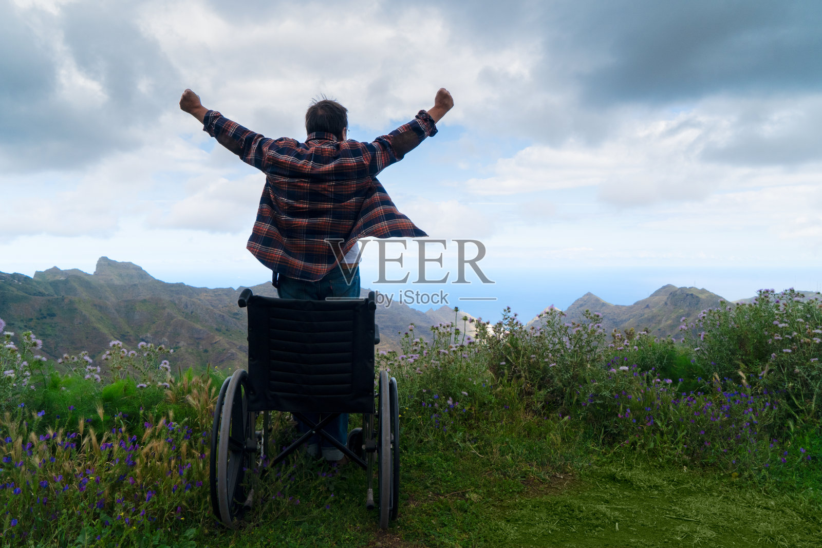 坐在轮椅上的残疾妇女在山上欣赏风景照片摄影图片