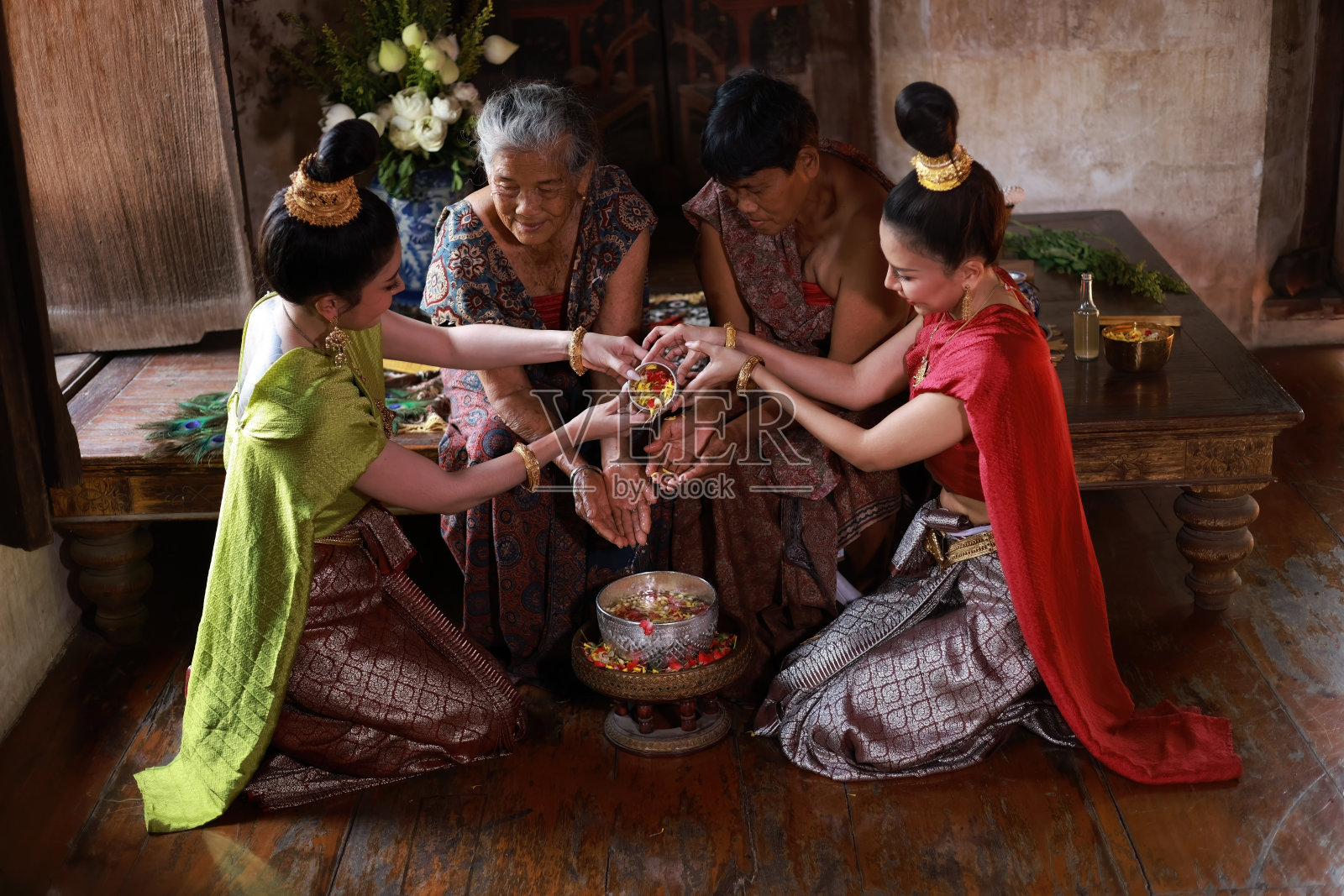 美丽的亚洲女子穿着泰国传统服装向保留长老的手倒水并祈求祝福,泰国的宋干节和文化照片摄影图片