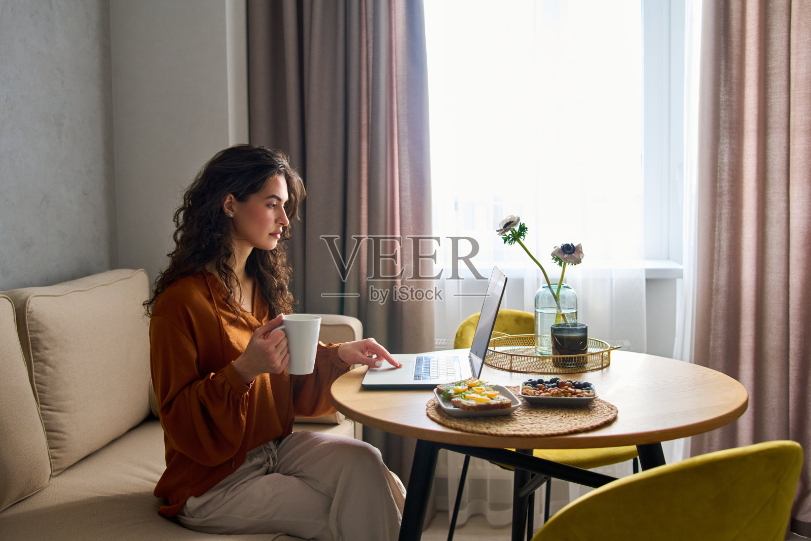 年轻认真的女性数字游牧民早餐时在网上工作照片摄影图片