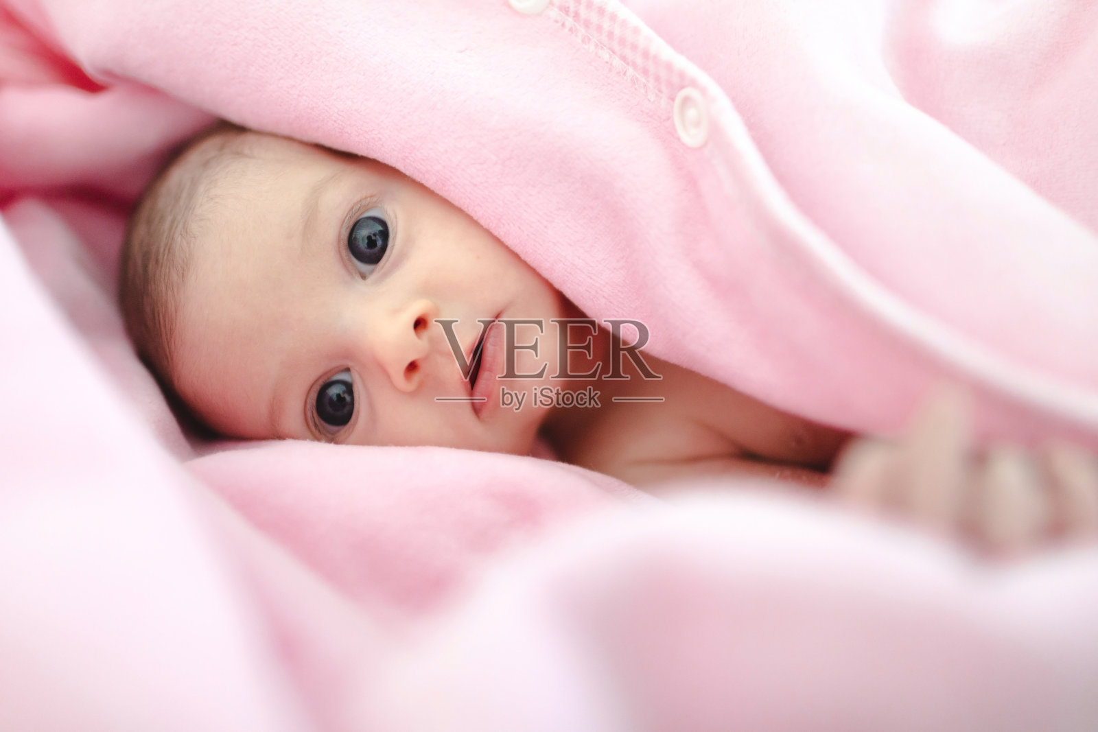 新生儿躺在粉红色的毯子上照片摄影图片