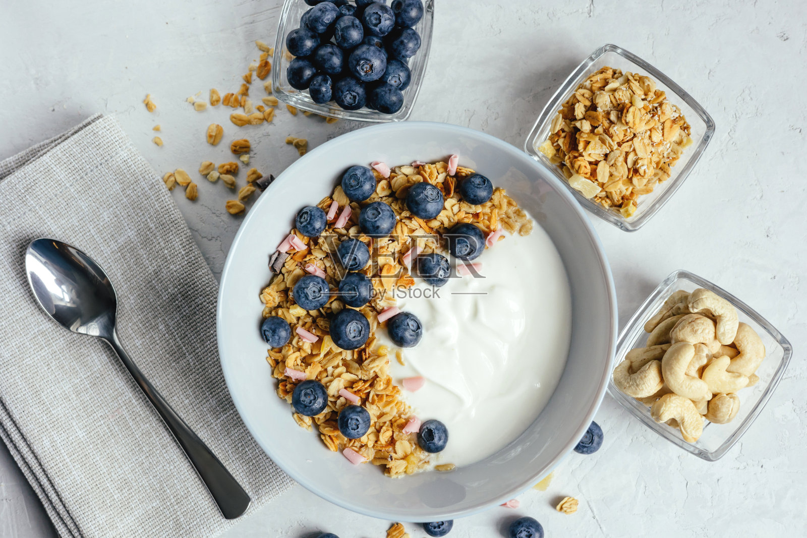 灰色背景的酸奶配什锦麦片和浆果。照片摄影图片