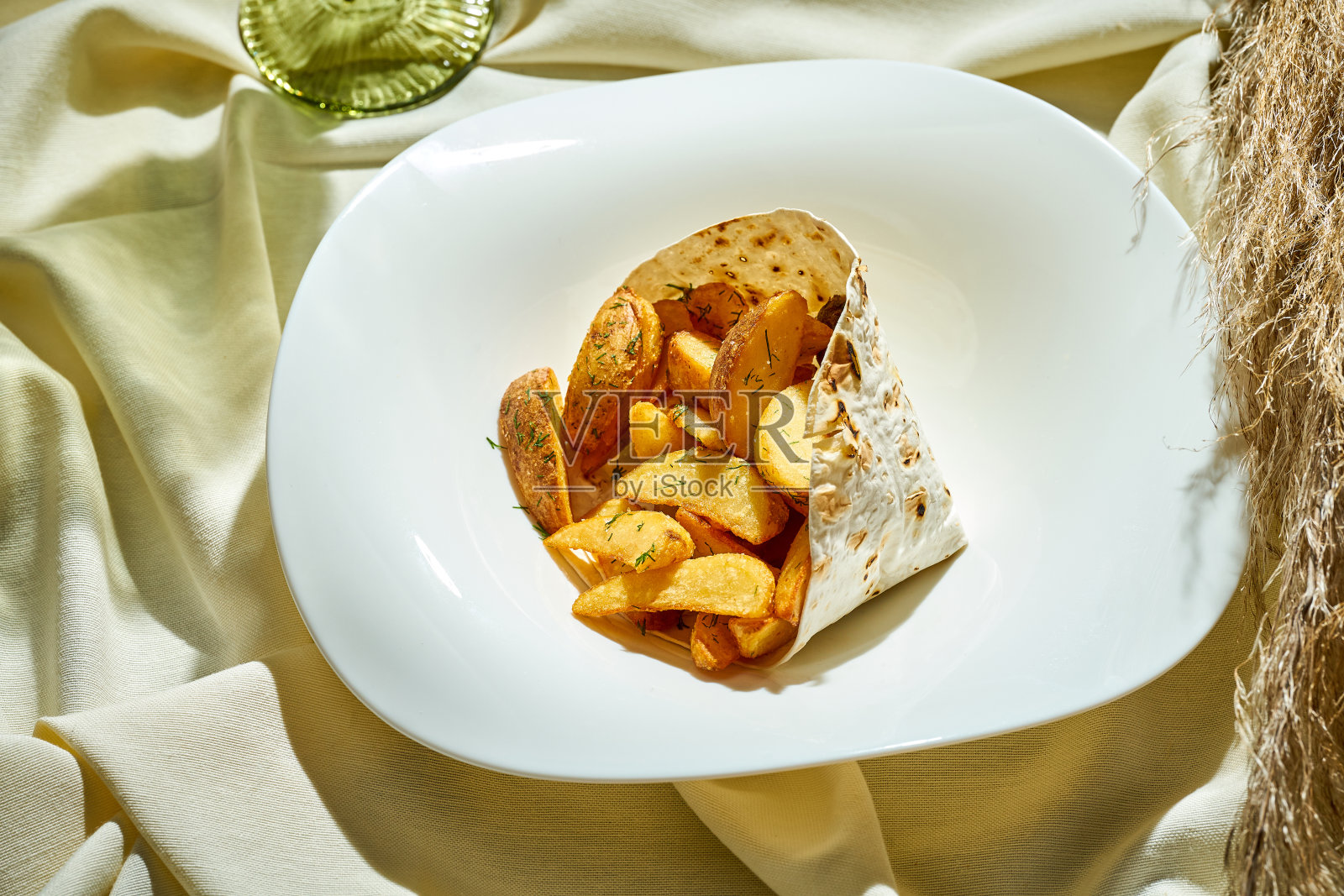 盛在盘子里的香料烤土豆。有选择性的重点照片摄影图片