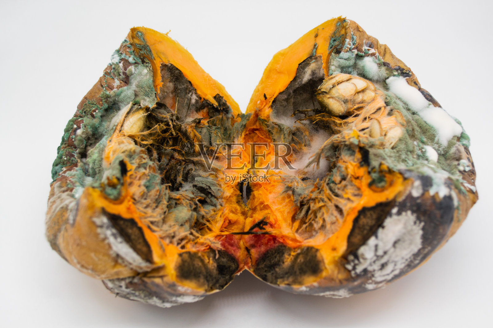 一个腐烂的南瓜在白色背景上切成两半的特写照片摄影图片