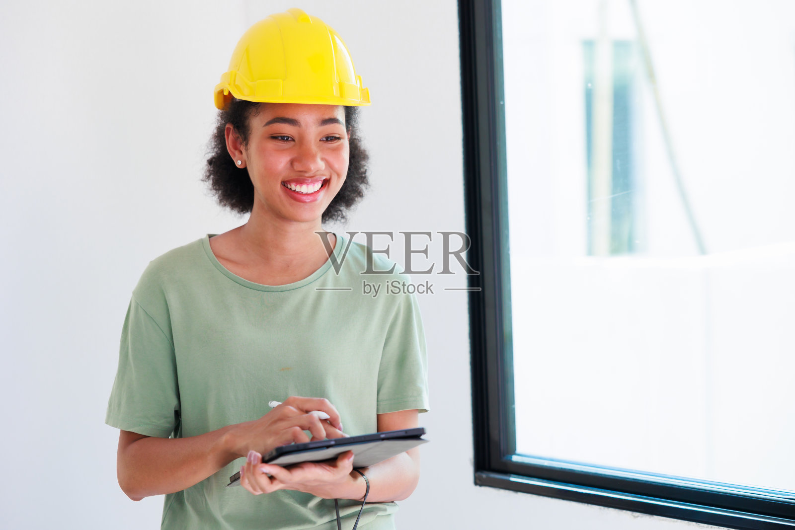 肖像快乐微笑的黑人妇女。专业的黑人女工程师和检查员在住房项目中调查在建房屋的整洁程度。照片摄影图片