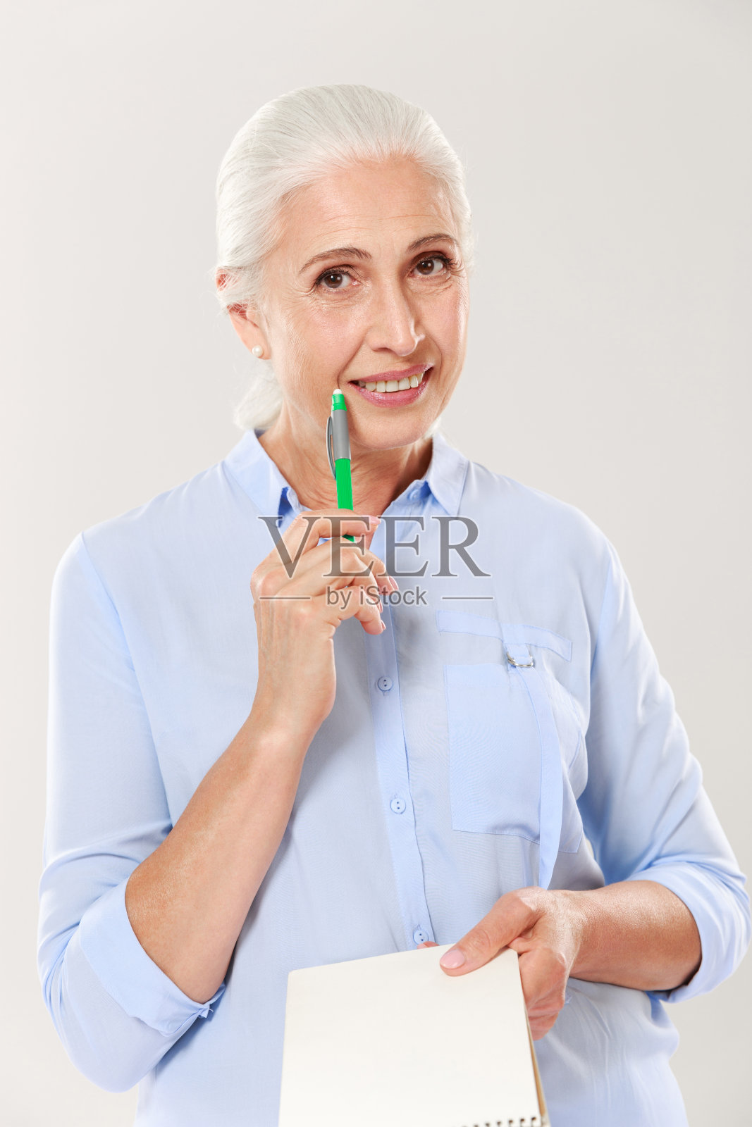 快乐的女人与笔和笔记本看相机和微笑照片摄影图片