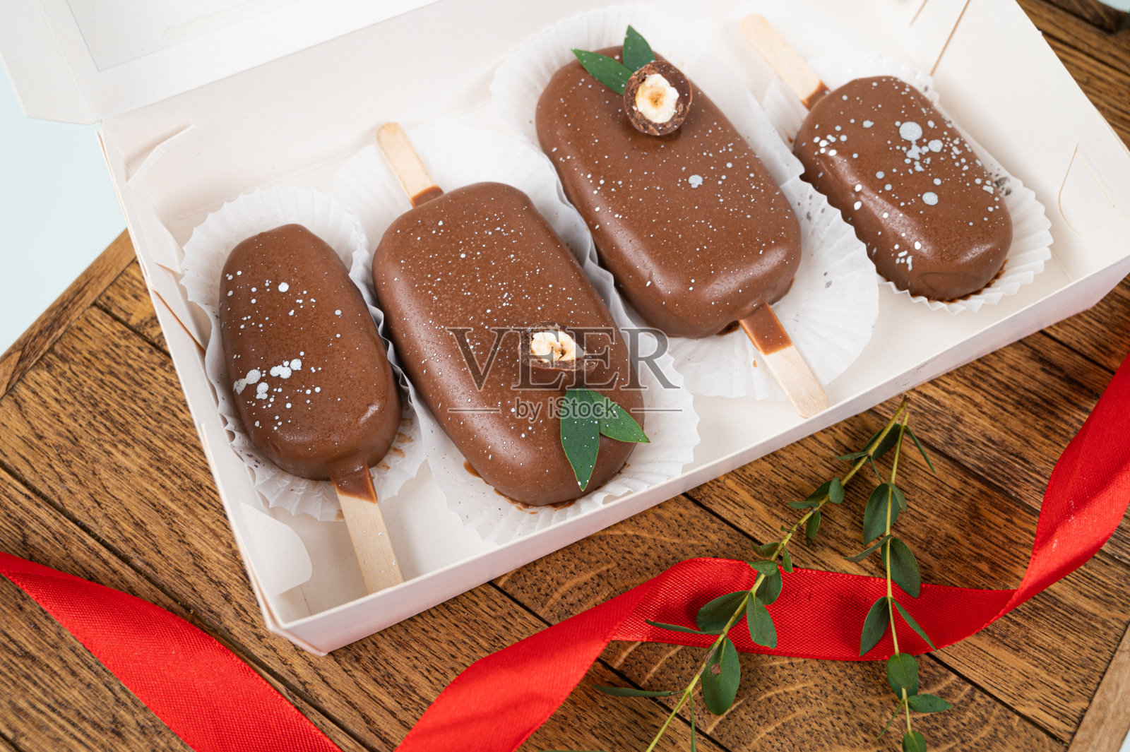 节日点心盒子。巧克力蛋糕以冰淇淋的形式出现在木架上,俯视图。概念的食物照片摄影图片