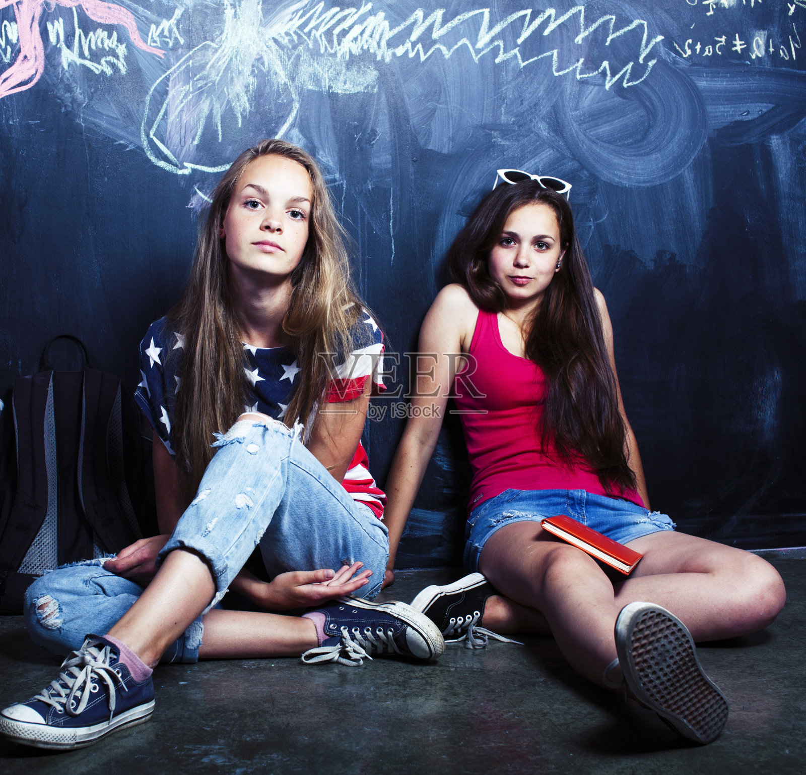 暑假后回到学校,两个十几岁的女孩在教室里用黑板涂漆照片摄影图片