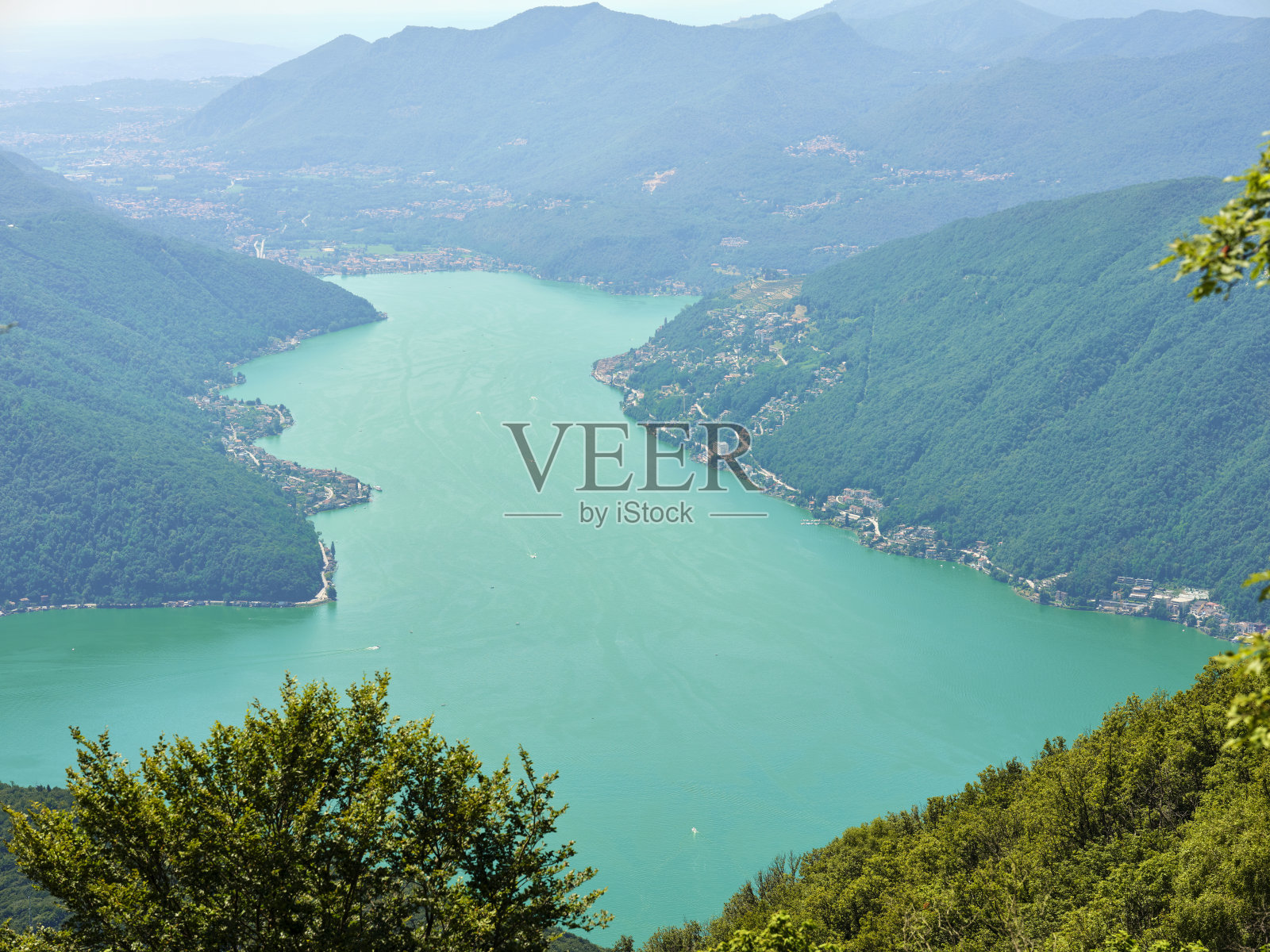 从意大利因特尔维山谷俯瞰卢加诺湖。背景是瑞士的阿尔卑斯山。生活方式,自由和冒险的概念。照片摄影图片