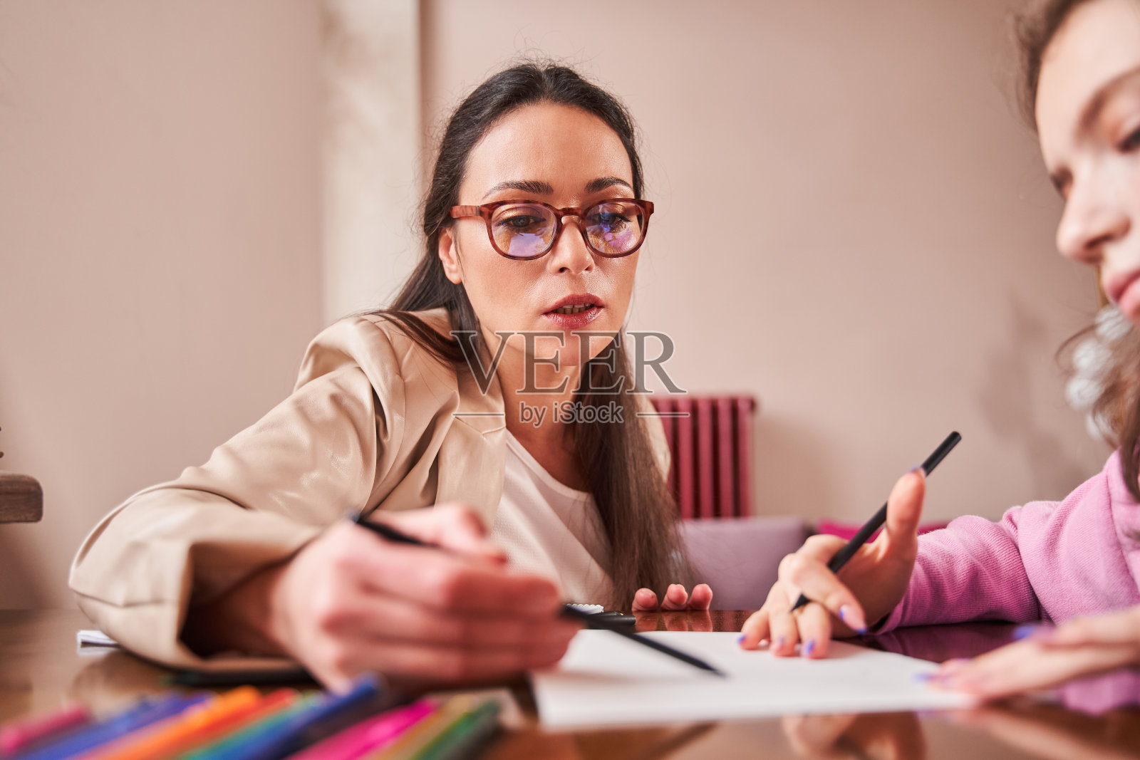 治疗师在诊疗期间为绘画的青少年患者提供建议照片摄影图片