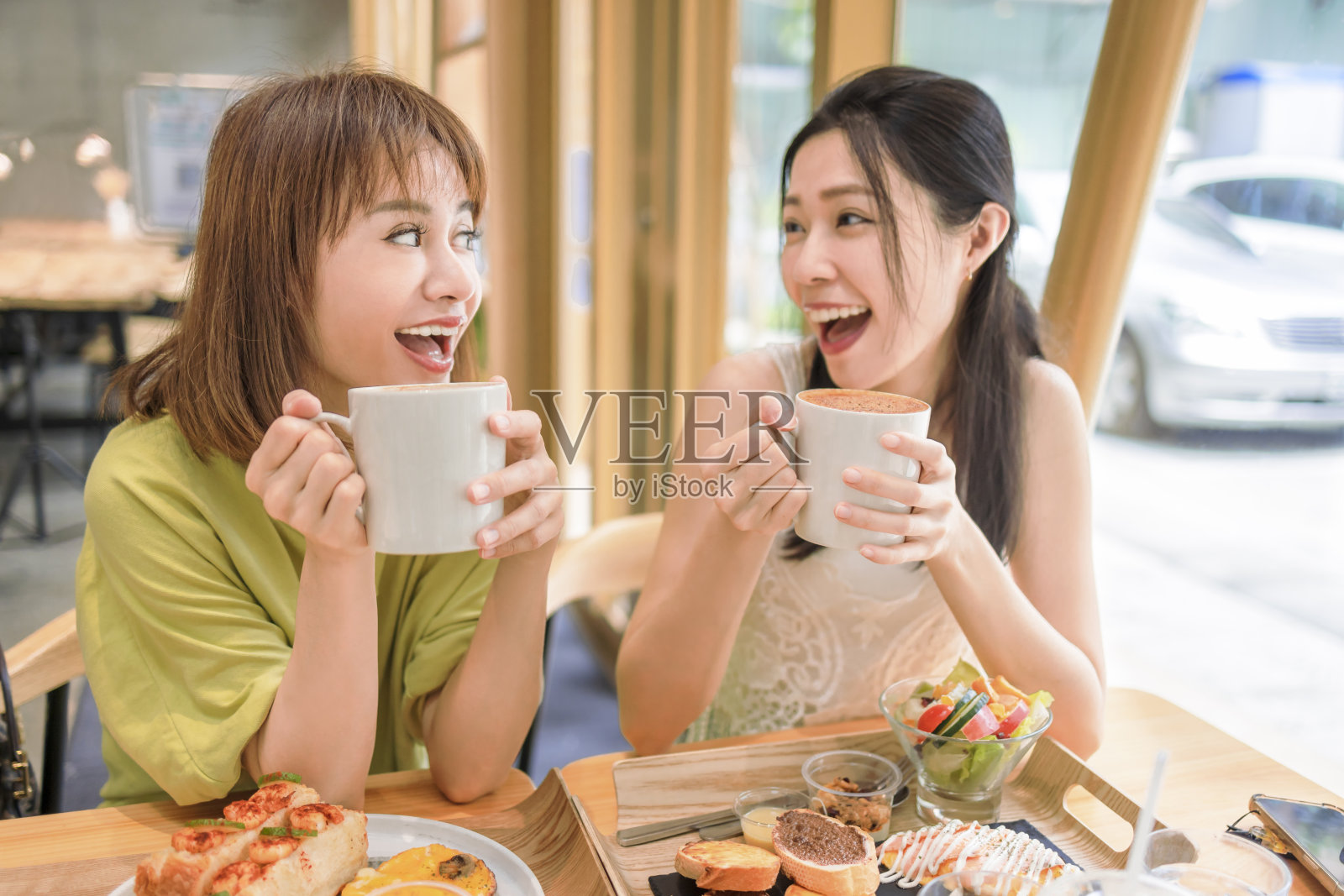 在咖啡馆喝咖啡的快乐年轻女性照片摄影图片