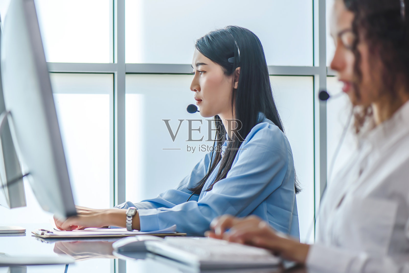 年轻友善的女接线员,戴着耳机。照片摄影图片