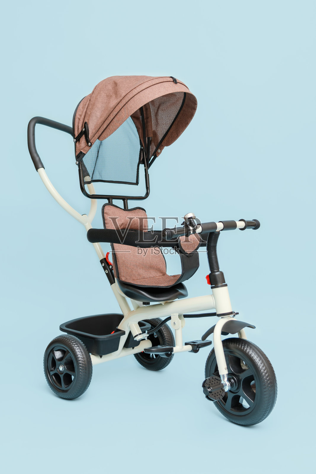 蓝色背景下的儿童三轮车。照片摄影图片