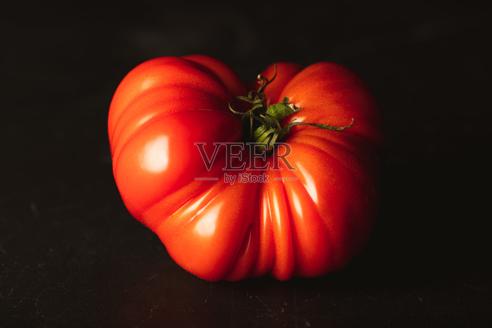 新鲜成熟的番茄牛排在黑色的背景照片摄影图片