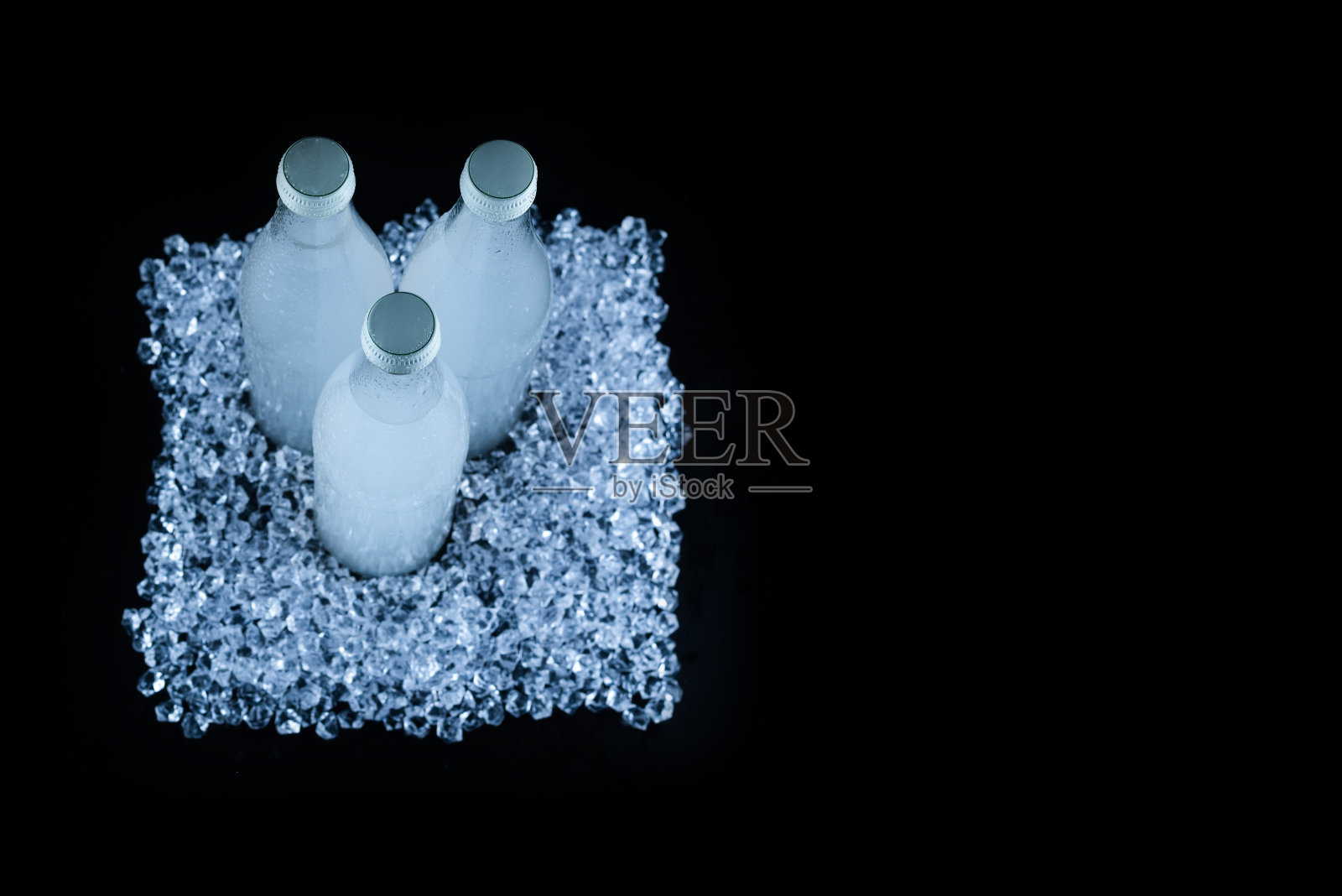 一个白色的瓶子,里面放着加冰的苏打饮料。照片摄影图片