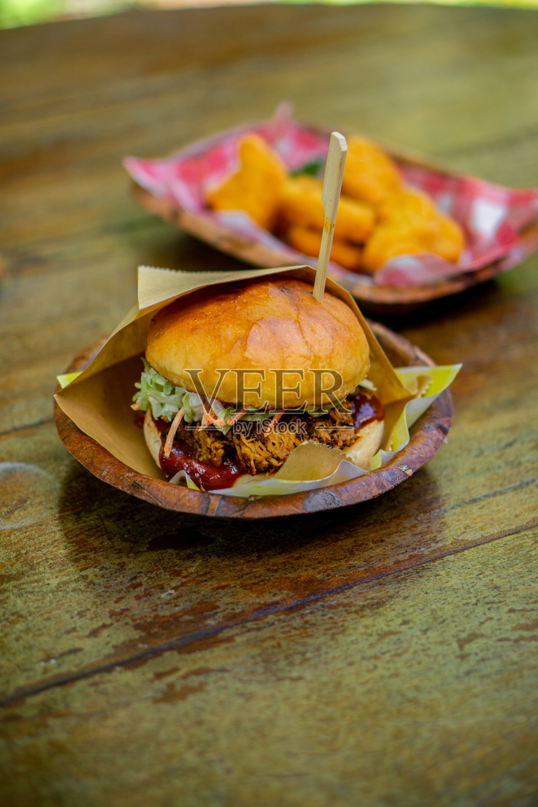 一个大汉堡放在一张木桌上。照片摄影图片