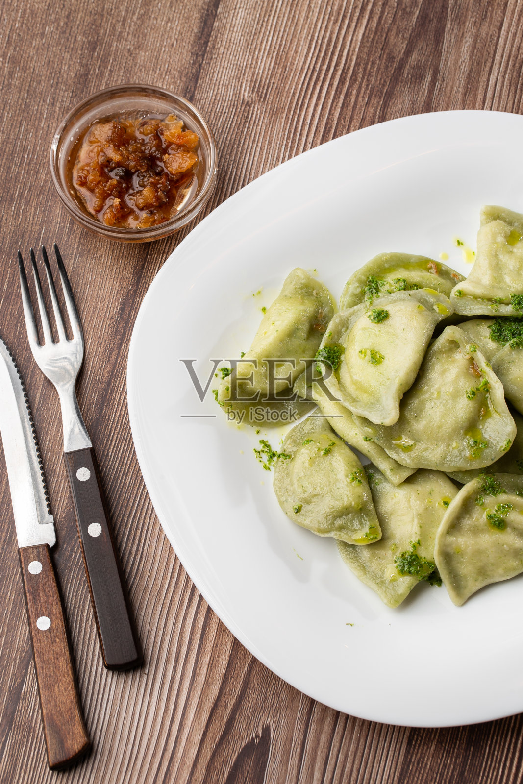 传统的乌克兰菜vareniki与罗勒和罗勒酱一起盛在碗里。近距离观察传统的乌克兰食物照片摄影图片