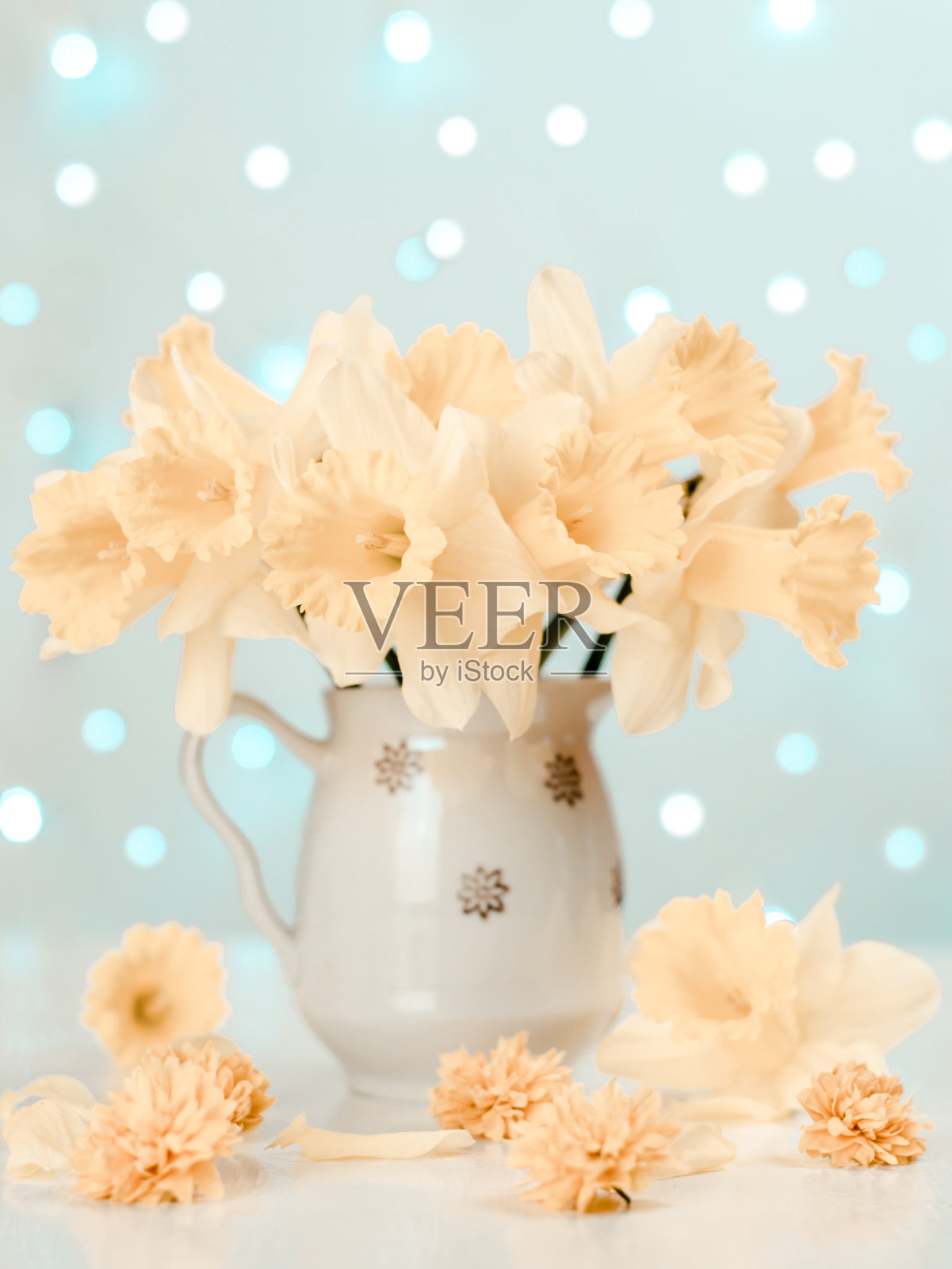 春天的明信片。在明亮的灯光的背景下,桌子上水壶里的黄水仙花束。春天的作文。有选择性的重点。照片摄影图片