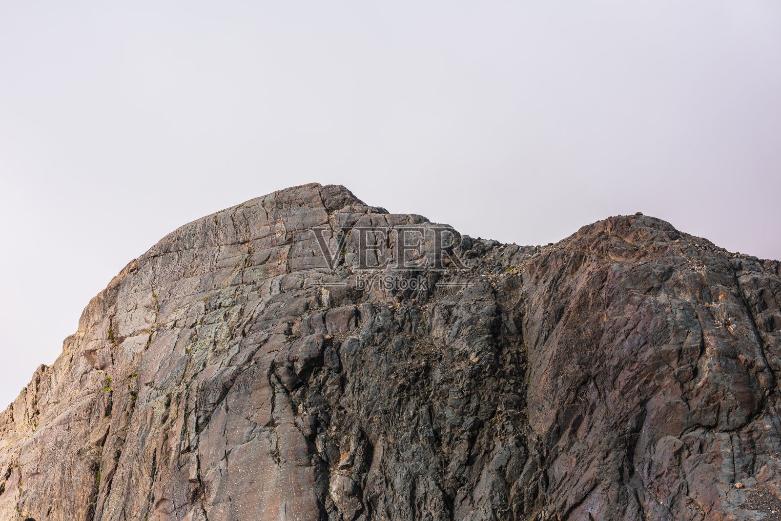极简主义景观,阳光下的岩石山壁晴朗的天空。阳光下最小的山景与高岩壁。简单的极简主义,阳光下的岩石。金色阳光下的山顶照片摄影图片